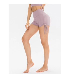Detail of high-waisted mauve yoga shorts with side drawstring and ruched texture