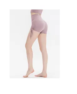 Detail view of mauve high-waisted yoga shorts featuring side drawstring and ruched design