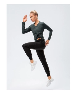 Vue dynamique du haut de yoga à manches longues avec nœud et pantalon de sport respirant