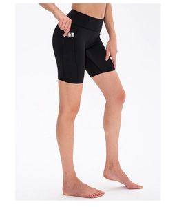 Close-up of women's black high-waisted yoga shorts with functional side pocket for cards