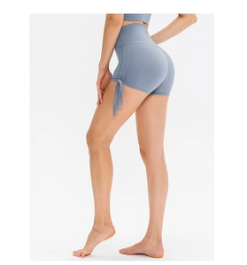 Detail of high waist yoga shorts featuring adjustable side drawstrings and ruched texture