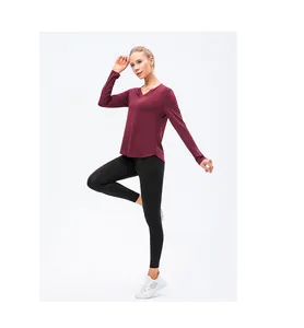 Détail du haut de yoga bordeaux à col en V et legging noir avec poche latérale pratique