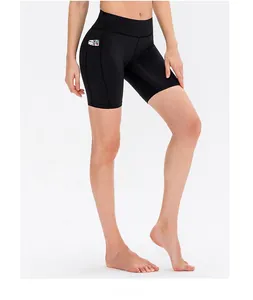 Detail of high-waist black yoga shorts featuring a functional side pocket and stretch fabric