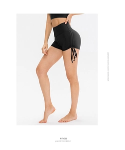 Detail of high waist yoga shorts featuring side drawstring and ruched design in black