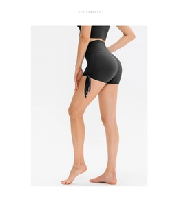 Detail of high waisted black yoga shorts featuring adjustable side drawstring and ruched texture