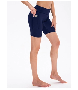 Detail shot of navy high-waisted yoga shorts showing a functional side pocket with card