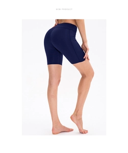 Detail view of navy blue high-waisted yoga shorts with side pockets and ergonomic seams