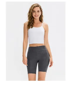 Front view of women's white camisole and high-waisted dark grey yoga shorts set