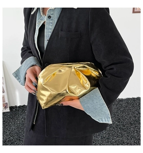 Pochette nuage dorée chic en similicuir plissé tenue à la main par un mannequin
