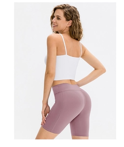 Detail view of pink high-waisted yoga shorts with side pocket and moisture-wicking fabric