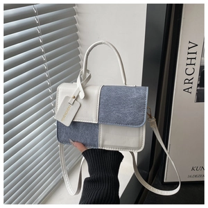 Detail showing blue and white color-block contrast texture on a fashion square handbag