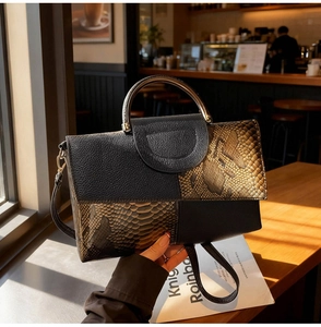 Detail of faux snake skin texture and leather patchwork on women's vintage handbag