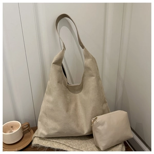 Detail view of beige hobo tote bag and matching zipper pouch in a warm lifestyle setting