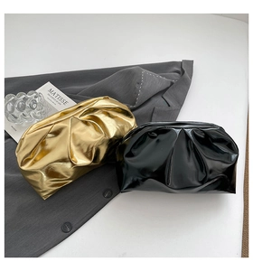Vue à plat de pochettes froncées dorées et noires avec un design tendance en nuage