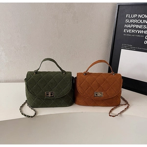 Detail of quilted suede handbags in olive and caramel with gold chain straps