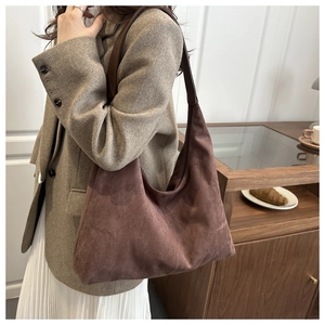 Detail view of large brown suede hobo bag with wide shoulder strap and vintage texture