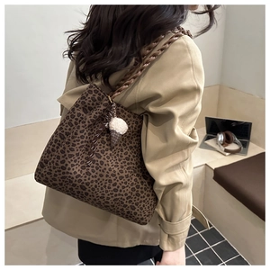 Detalle de bolso tote con estampado de leopardo, correas de cuero y colgante de helado