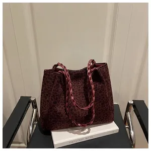 Detail view of the leopard print tote bag with woven handles on a stylish setup