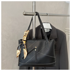 Detail of black tote bag with white contrast stitching and silk scarf wrapped handle