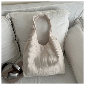 Detail of off-white pleated fabric tote bag with vertical stripes and Fashion label