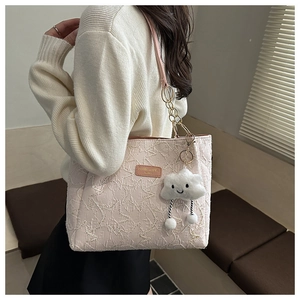Detail of pink star-quilted tote bag featuring plush cloud charm and metal chain strap