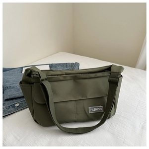 Detail of army green nylon messenger bag with fashion label and adjustable strap