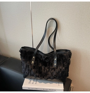 Detail of black faux fur tote bag with layered wave texture and leather bottom