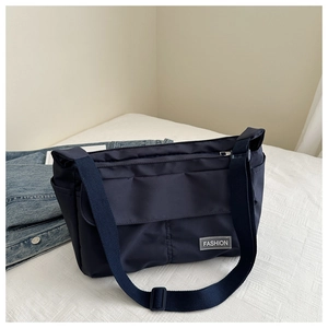 Detail of navy nylon messenger bag with multi-pockets and adjustable shoulder strap
