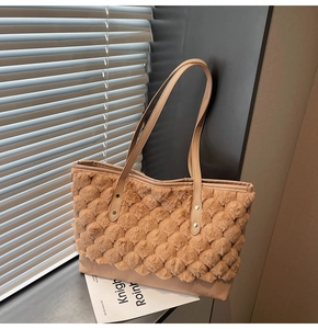Detail of plush textured fabric and smooth leather patchwork on beige tote bag