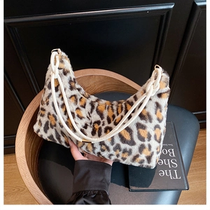 Détail du sac hobo en fausse fourrure léopard avec cordes tressées et anneaux dorés