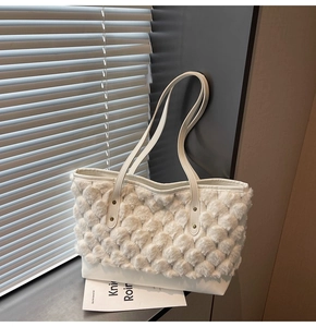 Detail of white plush tote bag with wavy texture and leather bottom on window sill