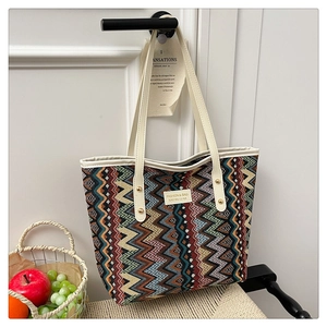 Close-up of woven tote bag featuring retro colorful geometric patterns and leather strap
