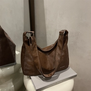 Retro brown distressed leather dumpling shoulder bag with white lettering and silver buckle