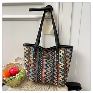 Detail of colorful chevron woven tote bag with leather straps and gold rivets