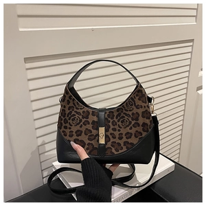 Detailed view of leopard print faux suede handbag with rose texture and golden metal twist lock