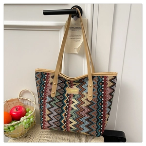 Detail of colorful geometric wave pattern tote bag with leather handles and rivets