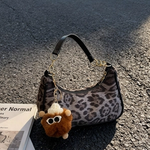 Leopard print plush crescent bag with black leather strap and brown monster charm