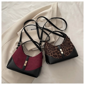 Detail of shell-shaped bags in burgundy suede and leopard print with gold clasps