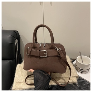 Detail of dark brown matte leather handbag with metallic buckle and detachable shoulder strap