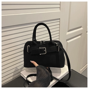 Detail of black suede handbag with wide belt buckle and adjustable shoulder strap