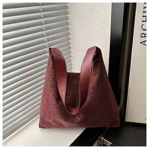 Close-up of burgundy leopard print nylon tote bag with premium leather handles