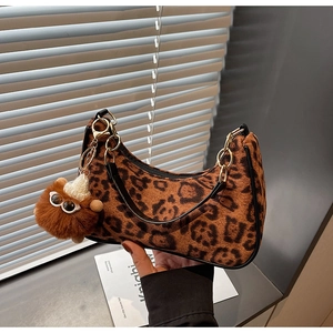Dettaglio borsa hobo leopardata con catena dorata e ciondolo in peluche morbido