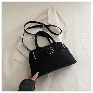 Detail of black belt buckle shell bag on white suit with adjustable shoulder strap