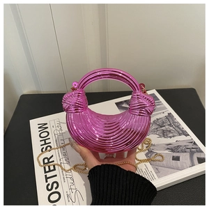 Detail showing bright pink metallic half-moon bag with pleated texture and gold chain