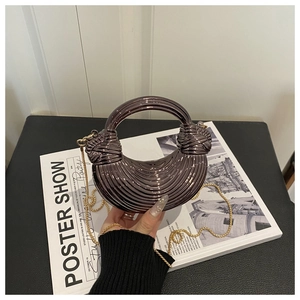 Detail of metallic striped half-moon bag with circular handle and gold chain strap