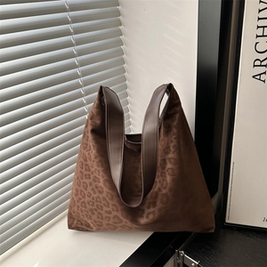 Chic leopard print oversized tote bag with premium leather handles on a sunlit ledge