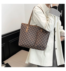 Detailed view of checkered tote bag with matching pouch and brown leather strap