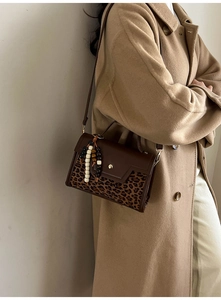 Detail of vintage patchwork handbag with leopard print and beads on a wool coat