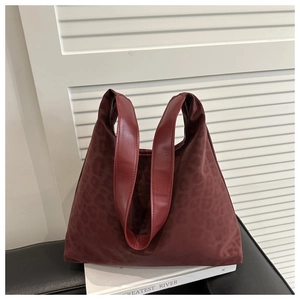 Detailed view of burgundy leopard print handbag textured fabric and sturdy handles