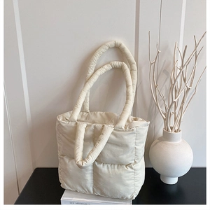 Quilted puffer tote bag in off-white finish showing dual handles and nylon texture